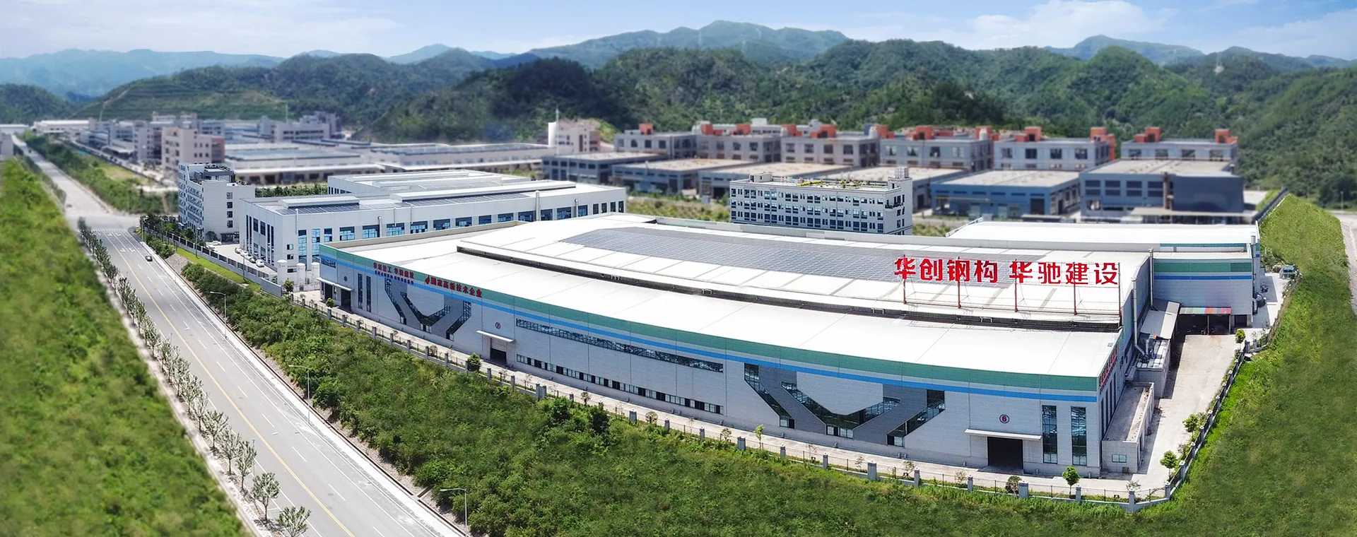 Huachuang factory campus beside forested mountains